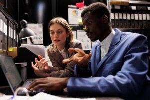 A man and woman looking at a computer screen in the wake of the Crowdstrike outage