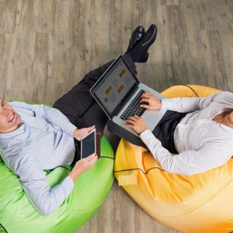 Hybrid worker using a laptop in a modern coworking space.